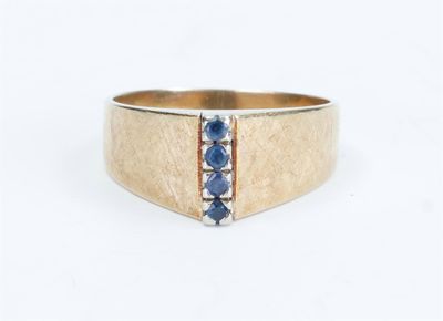 an image of a gold ring with blue sapphires