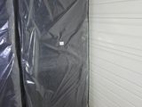 deux matelas emballés dans du plastique dans un débarras