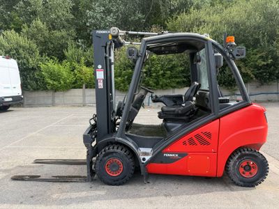 un chariot élévateur rouge garé sur un parking