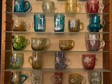 de nombreuses tasses et mugs sur les étagères du placard