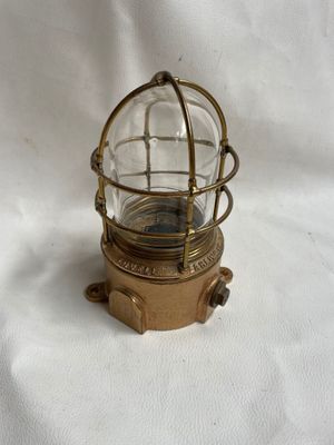 un vieux luminaire en laiton et en verre, surmonté d'un dôme en verre