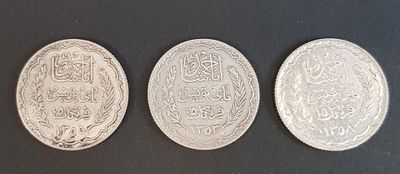 three silver coins sitting on top of a table next to each other