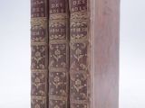 three old books sitting on top of each other on a white surface