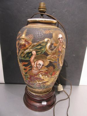 a vase with a painting on it sitting on a table
