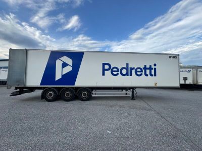 the semi trailer is parked in a parking lot with a blue and white logo on the side