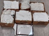 several boxes of white clothing are sitting on the floor