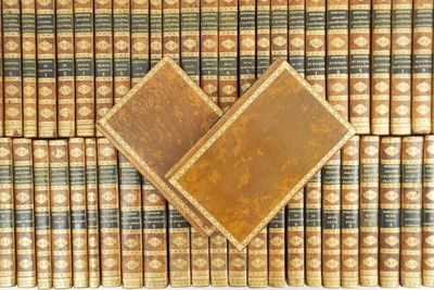 a large collection of old books stacked on top of each other