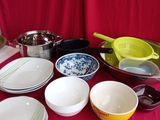 many bowls and pans on a table with red cloth