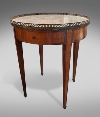 une table ronde avec un plateau en marbre et des pieds en bois