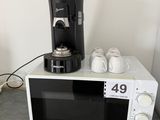un micro-ondes blanc sur lequel est posée une cafetière