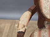 an antique chair with a floral upholstered back and arms