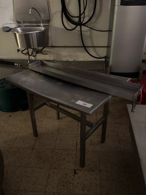 une cuisine équipée d'un évier et d'une table