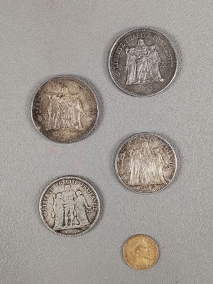 quatre types de pièces différents posés sur une surface blanche