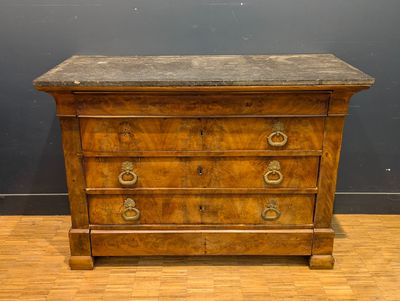 une vieille commode en bois avec un plateau en marbre, posée sur un parquet en bois massif