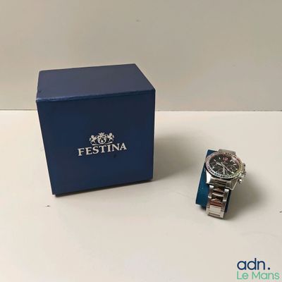 une photo d'une montre posée à côté d'une boîte bleue sur une table