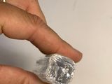 a woman ' s hand holding a piece of silver foil