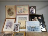 many framed pictures on the wall of a room
