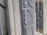 many mattresses wrapped up in plastic in a warehouse