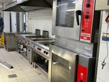 une grande cuisine équipée de nombreux appareils électroménagers