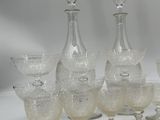 seven wine glasses and a decanter on the table