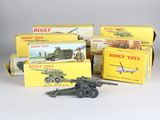 trois jouets Dinky Toys dans leur boîte, dont un véhicule militaire et un char d'assaut