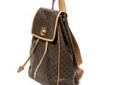 a brown and tan backpack with a brown handle on a white background