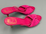 les chaussures roses sont posées sur une surface grise avec un fond argenté