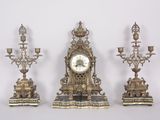 three antique clocks are sitting next to each other on a white surface