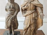 deux statues représentant une femme et un homme posées sur une table en bois