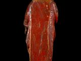an old statue of a man with a red robe and a hat