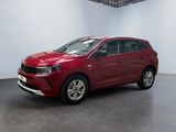 a red car is parked in a room with a white wall