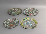 four chinese plates with floral designs on them sitting on a table