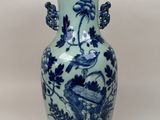 un vase bleu et blanc avec un oiseau dessus