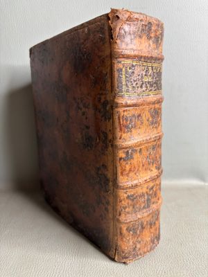 an old book sitting on top of a table next to a wall