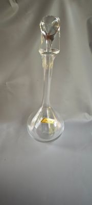 un vase en verre orné d'un papillon, posé sur une table