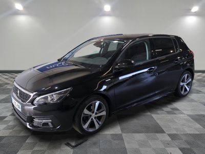 la voiture noire est garée sur un sol en damier dans le garage