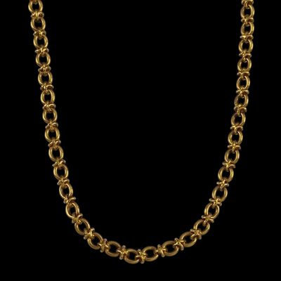 un collier à chaîne plaquée or avec un maillon circulaire sur fond noir