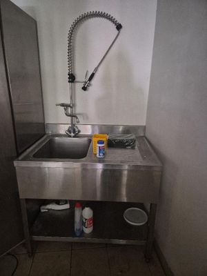 évier en acier inoxydable avec robinet dans des toilettes publiques