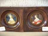 une paire de portraits encadrés représentant des femmes en costumes d'époque, sur des châssis en bois