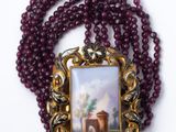 une photo d'un collier sur lequel figure l'image d'une église