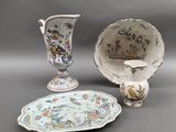 three different pieces of porcelain on display on a table