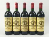 quatre bouteilles de vin sont alignées sur une surface blanche