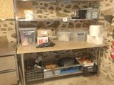 a kitchen with a stone wall and stainless steel shelvings