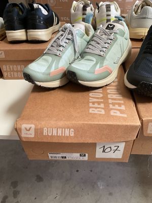 several pairs of running shoes sitting on top of boxes in a store