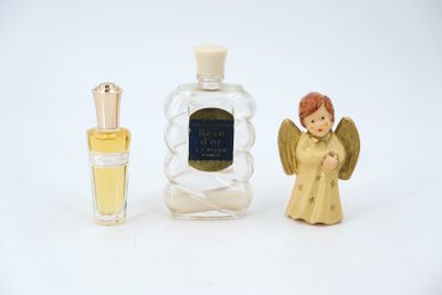 a small bottle of perfume next to a small angel figurine