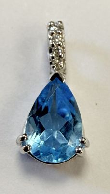an image of a blue topaz stone and diamond pendant on a white background