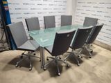 une table en verre entourée de chaises dans une pièce