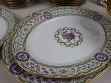 many plates and bowls on the table with gold rims