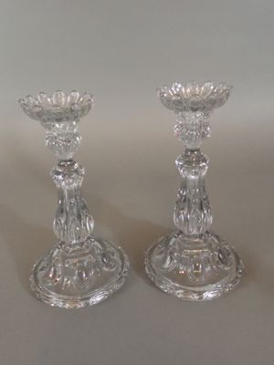 une paire de bougeoirs en verre transparent posés sur une table