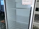 an empty refrigerator in the middle of a dirty room